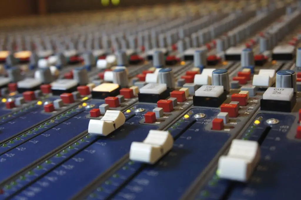 Recording studio desk - a close up of a mixing desk with many knobs